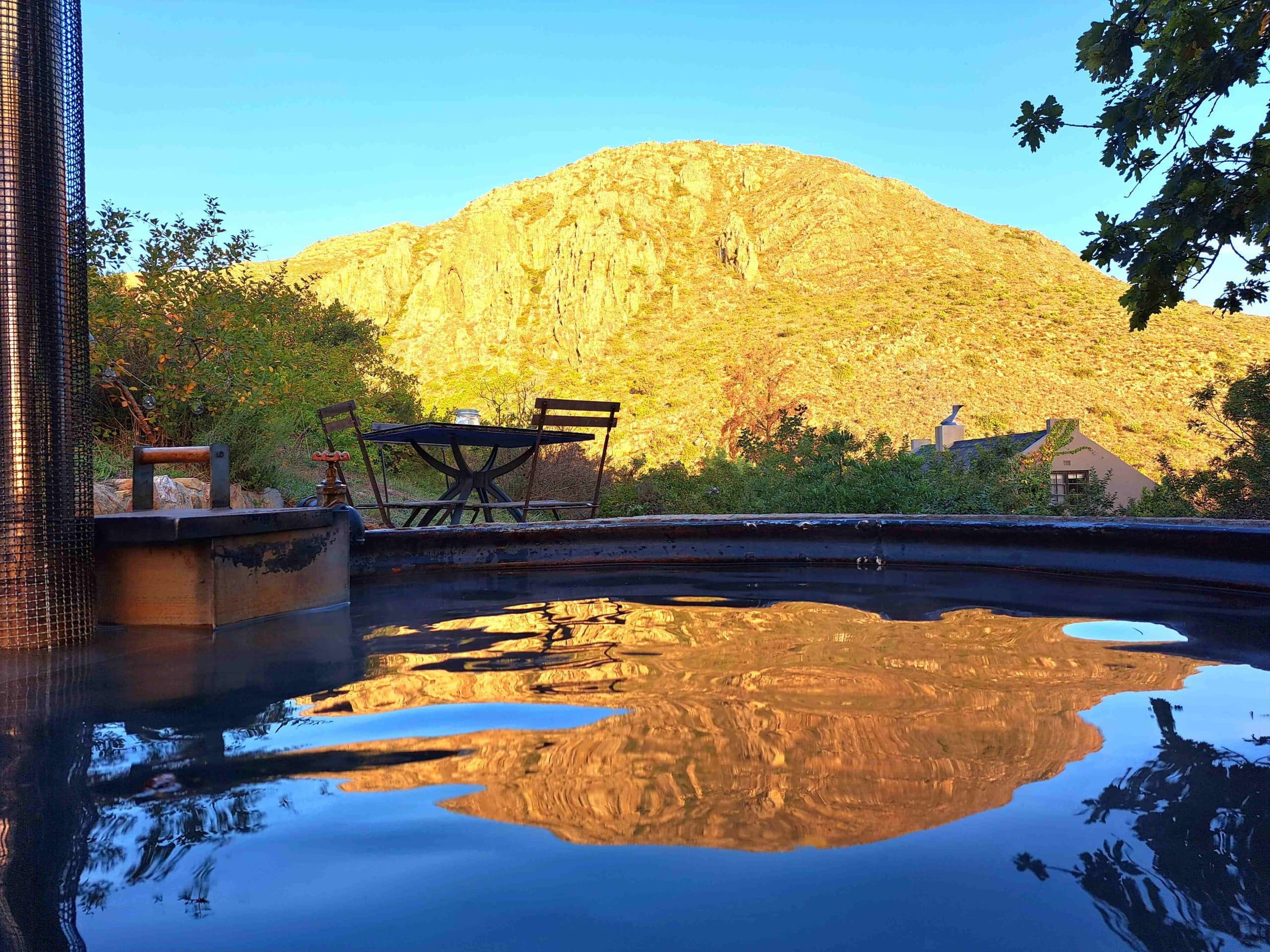 The Farmhouse at Porcupine Hills: Hot tub water reflecting golden mountain at dusk