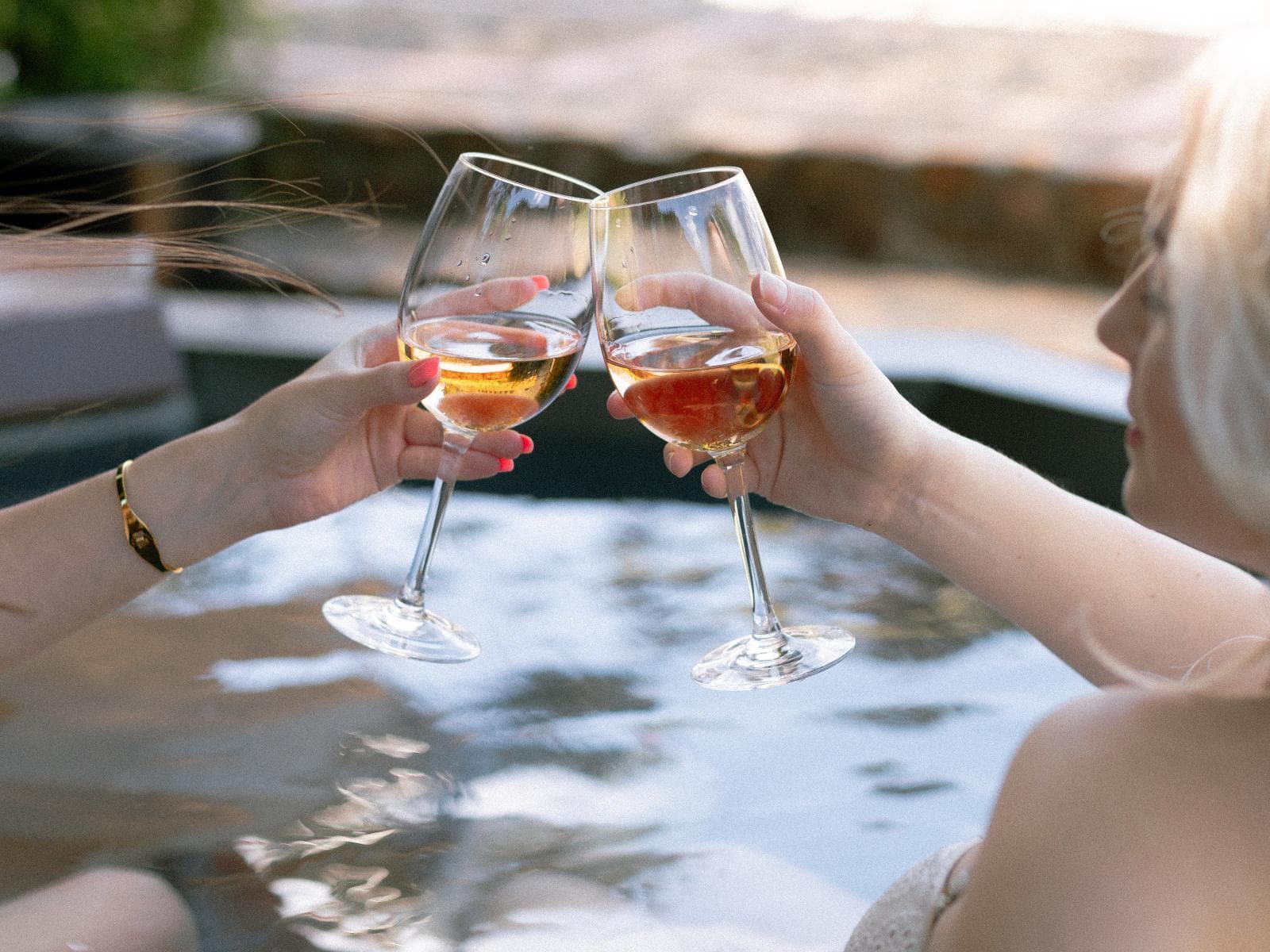 Luxury Pinot Noir Suite 1: Two women toasting rose wine in hot tub at dusk