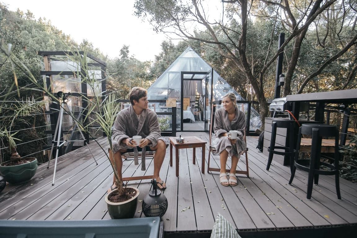 The Pyramid at Misty Mountain Reserve: Couple in robes on deck before glass pyramid in forest