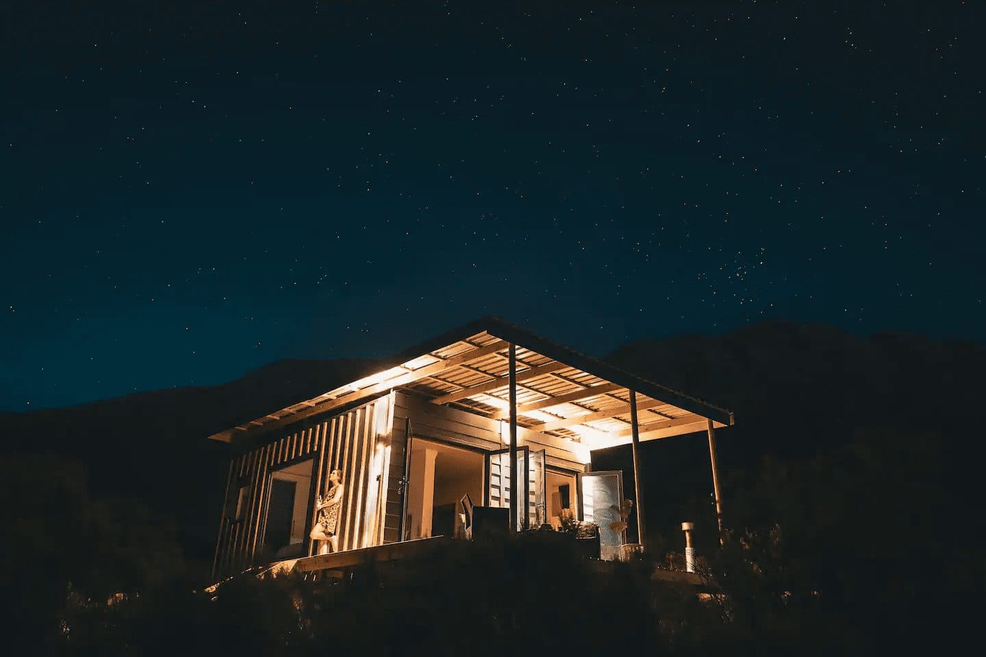 Radio Nowhere Cabin: Glowing cabin lit up under a starry night sky