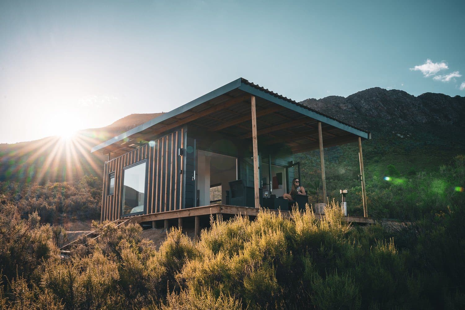 Radio Nowhere Cabin: Cabin at golden hour with sun flare and mountains