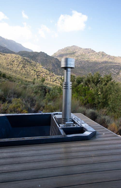 Better Days Cabin: Wood-fired hot tub with chimney, mountains and fynbos behind