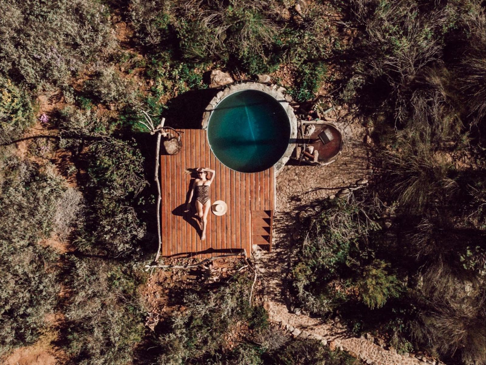 Leopard's Kloof Luxury Tented Camp: Aerial of round plunge tub with person sunbathing on deck