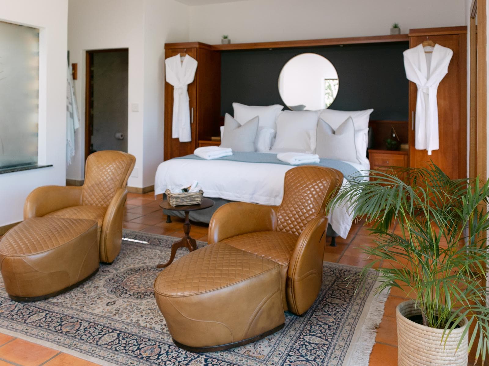 Pinot Noir Suite 2 at La Roche Estate showing a bed and brown armchairs