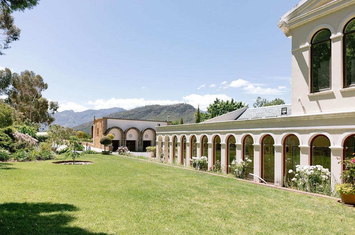 The Manor House: Arched colonnade estate, mountains, rose gardens, green lawn